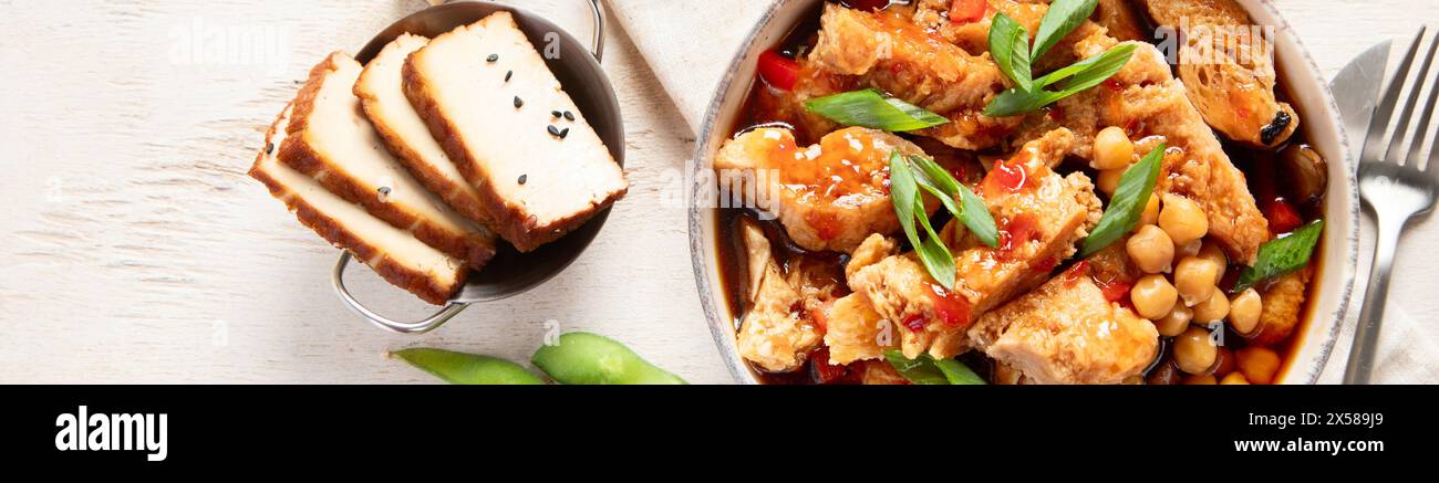 Sojabohnen mit Sojafleisch, Zwiebeln und Tofu auf hellem Holzhintergrund. Veganes Essen. Draufsicht, Kopierraum Stockfoto