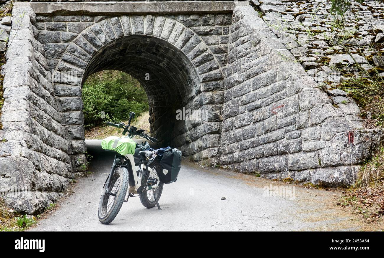 Fatbike parkte vor einer Unterführung aus rauen Natursteinen Stockfoto