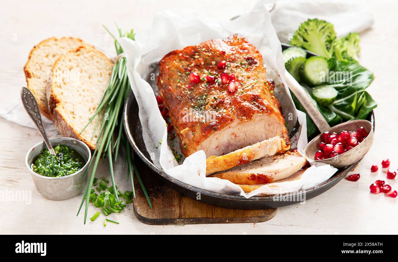 Gebackener Schinken in Scheiben mit Salat auf hellem Holzhintergrund. Traditionelles kulinarisches Konzept. Stockfoto