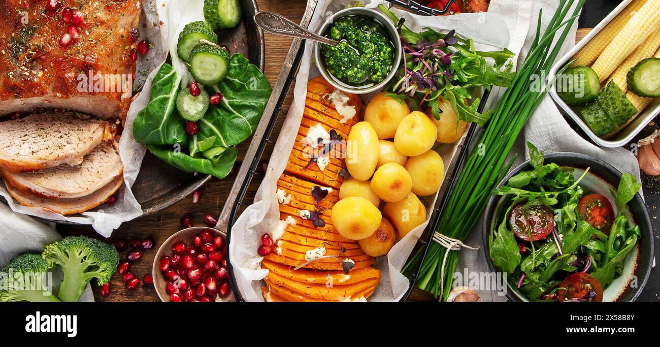 Gebratener Schinken mit Gemüse, Brot und frischem Salat auf schwarzem Hintergrund. Draufsicht. Panorama. Stockfoto