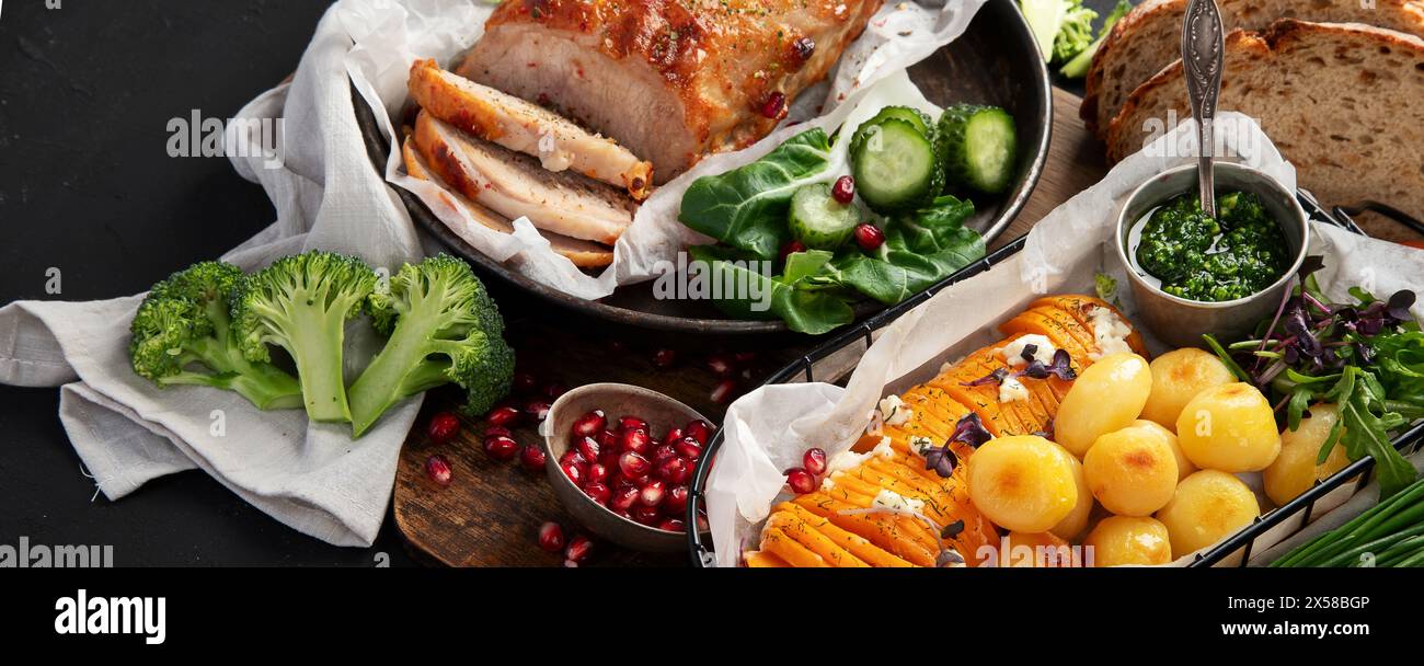 Gebratener Schinken mit Gemüse, Brot und frischem Salat auf schwarzem Hintergrund. Draufsicht. Stockfoto