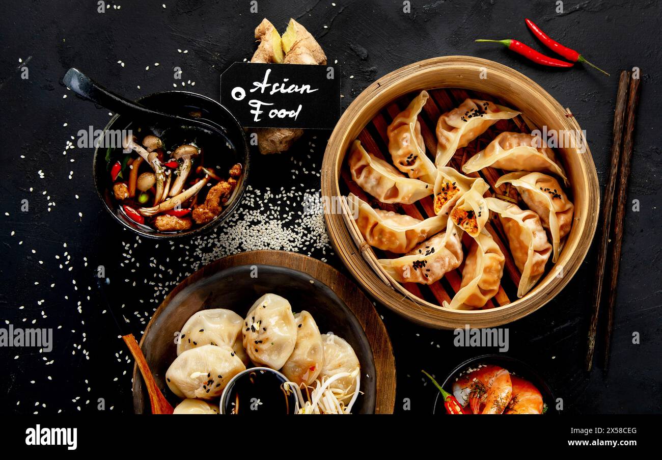 Chinesische Knödel, Sojasauce, Pilze auf dunklem Hintergrund. Traditionelles asiatisches Essenskonzept. Draufsicht Stockfoto