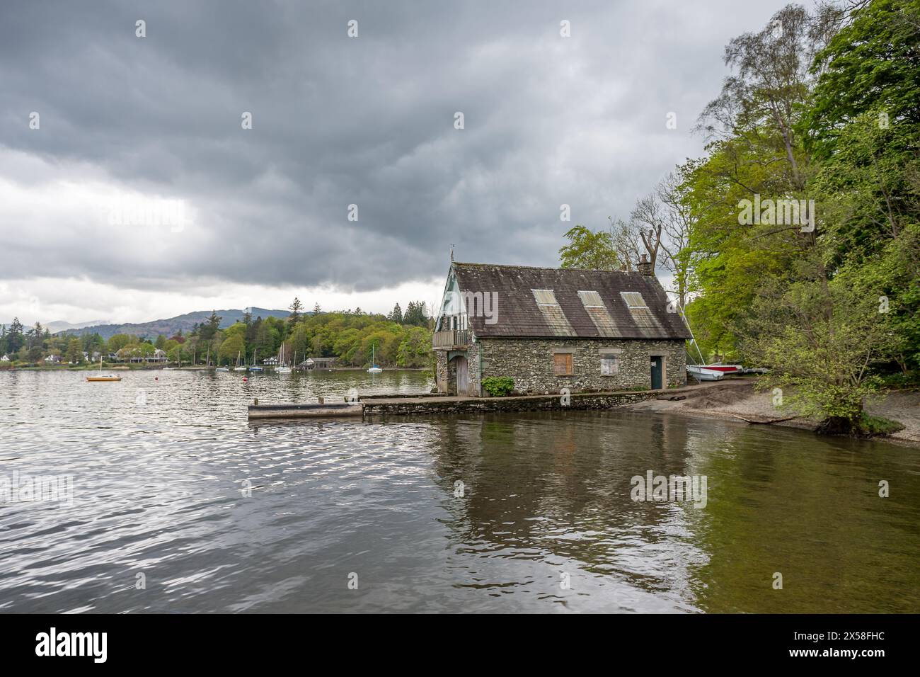 Ein traditionell gebautes Bootshaus, das sich am Lake Windermere in Rayrigg Meadow in Cumbria spiegelt und am 6. Mai 2024 gesehen wurde. Stockfoto