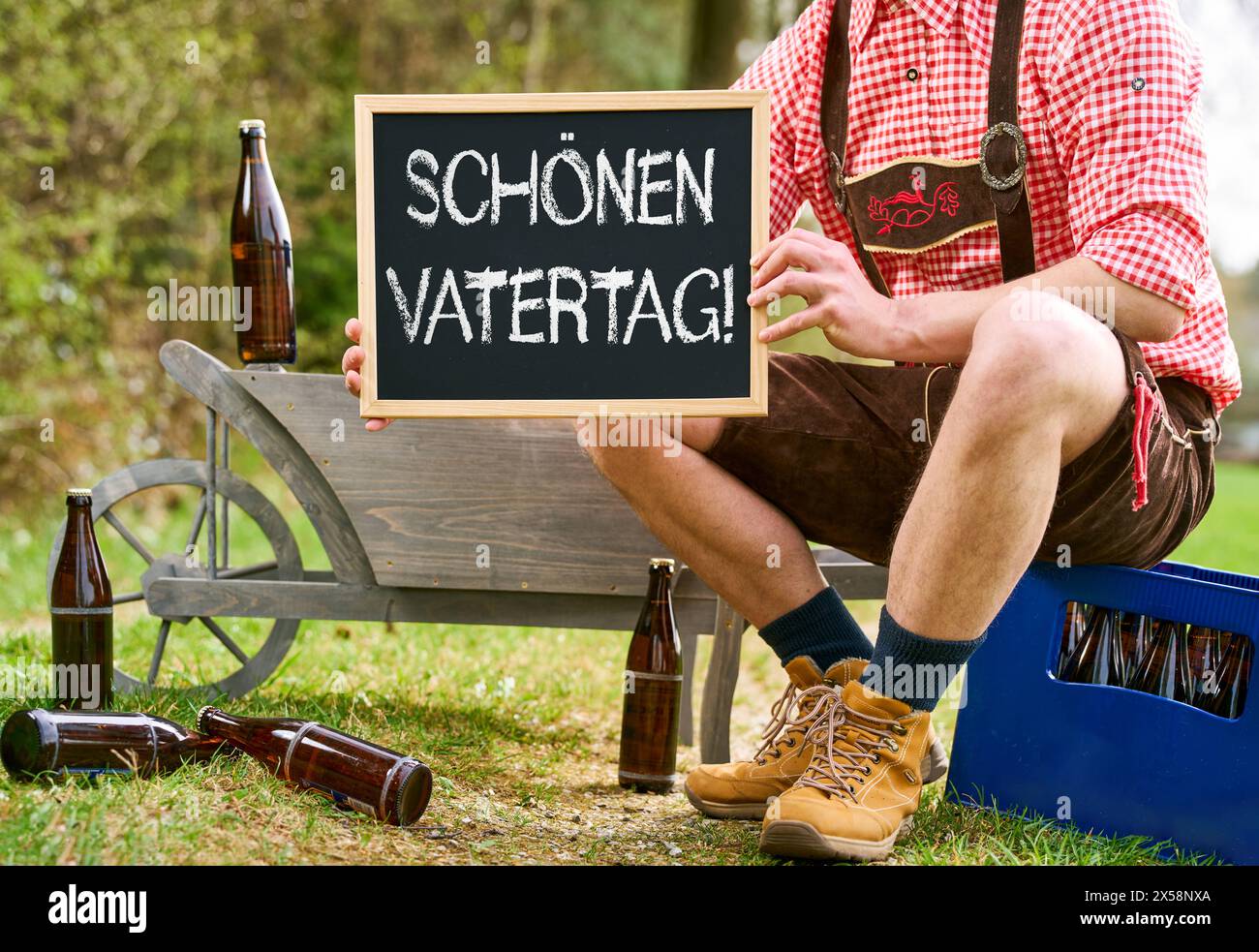 8. Mai 2024: Vatertag, Happy Vatertag, Grüße zum Vatertag. Bayerisch mit Handkarre, Bier und Schild. FOTOMONTAGE *** Vatertag, schöner Vatertag, Gruß zum Vatertag. Bayer mit Bollerwagen, Bier und Schild. FOTOMONTAGE Stockfoto