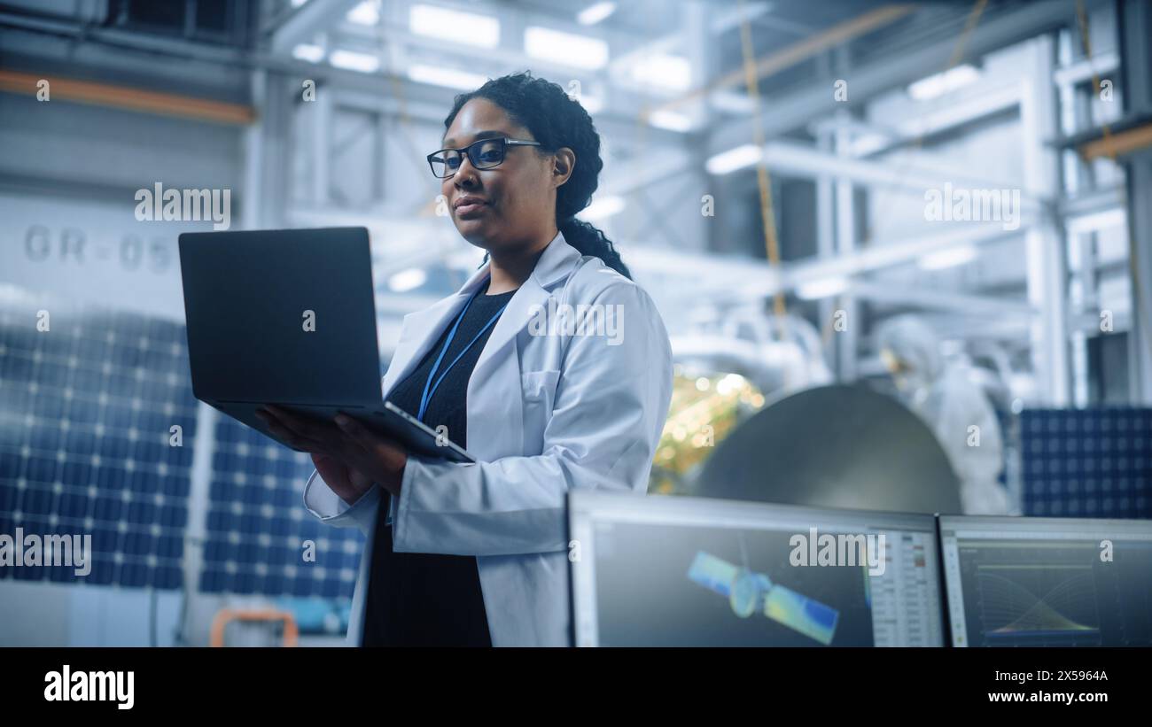 Porträt einer brillanten Ingenieurin mit selbstbewusstem und fokussiertem Denken, die in der Produktionsstätte für Satelliten in der Luft- und Raumfahrt arbeitet. Weltwissenschaftler, der das Programm für Wissenschafts- und Technologieforschung im Weltraum betreibt Stockfoto
