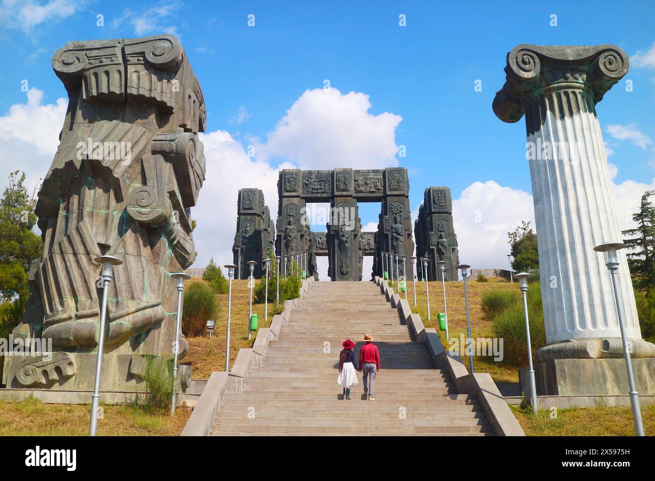 Ein Paar auf der Treppe der Chronik von Georgien, ein unglaubliches Denkmal auf dem Hügel in der Nähe von Tiflis, Georgien, geschaffen von Zurab Tsereteli i. Stockfoto