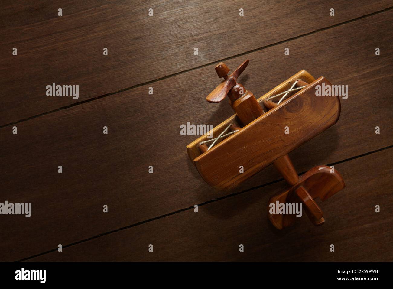 Draufsicht eines Holzspielzeugflugzeugs auf einem Holztisch im Hintergrund Stockfoto