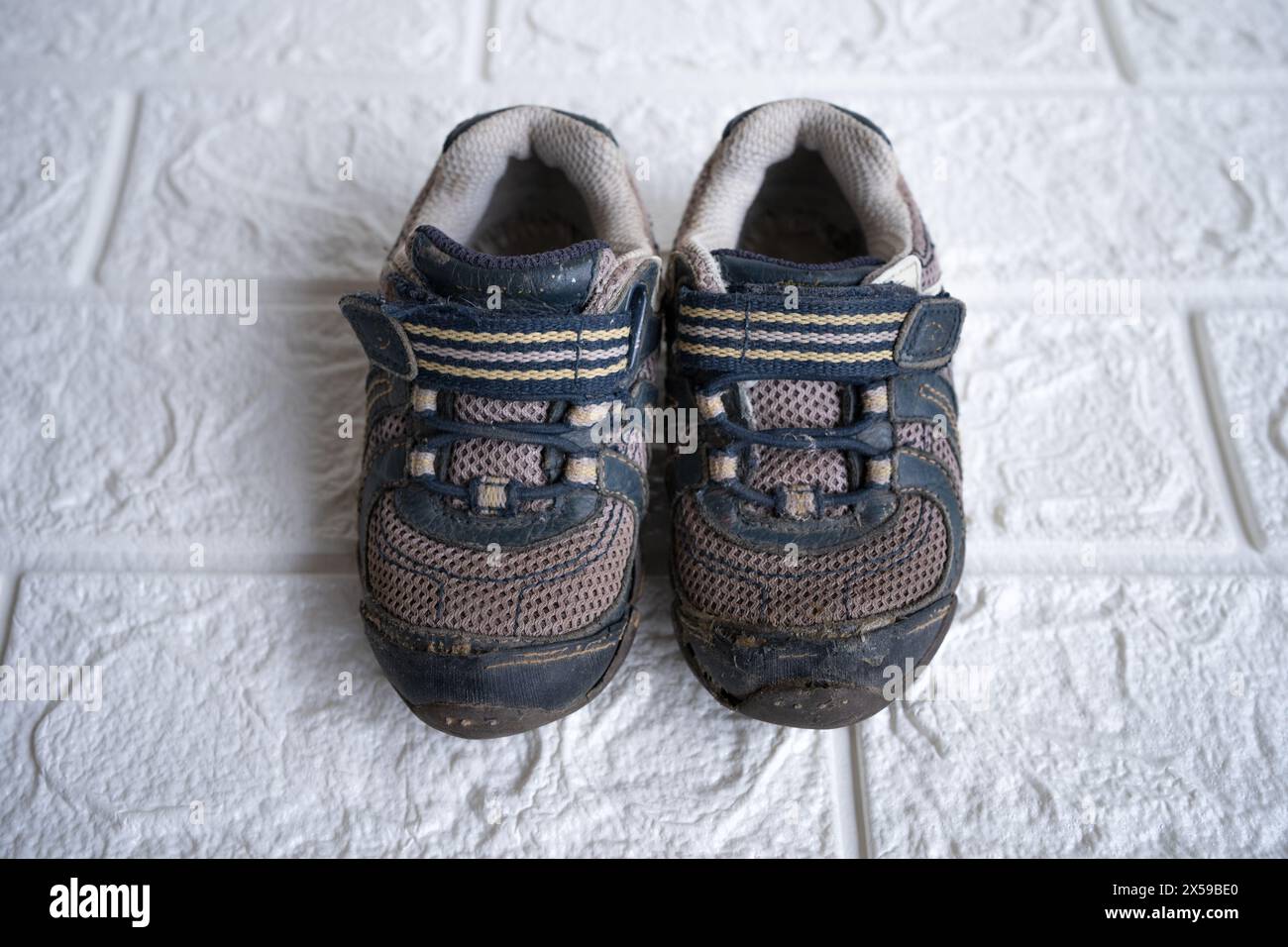 Alte Schuhe für Kinder oder Baby auf dem Boden. Stockfoto