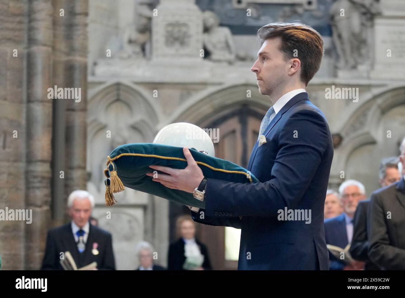 Sebastian Bell trägt den weißen Helm des verstorbenen F1-Rennfahrers Stirling Moss während einer Danksagung für Sir Stirling Moss in der Westminster Abbey in London. Bilddatum: Mittwoch, 8. Mai 2024. Stockfoto