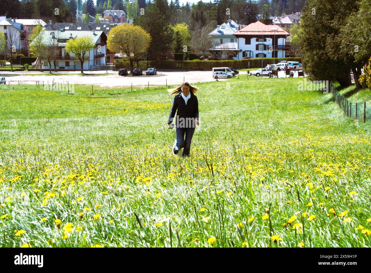 Das Mädchen, das auf dem Blumenfeld läuft Stockfoto