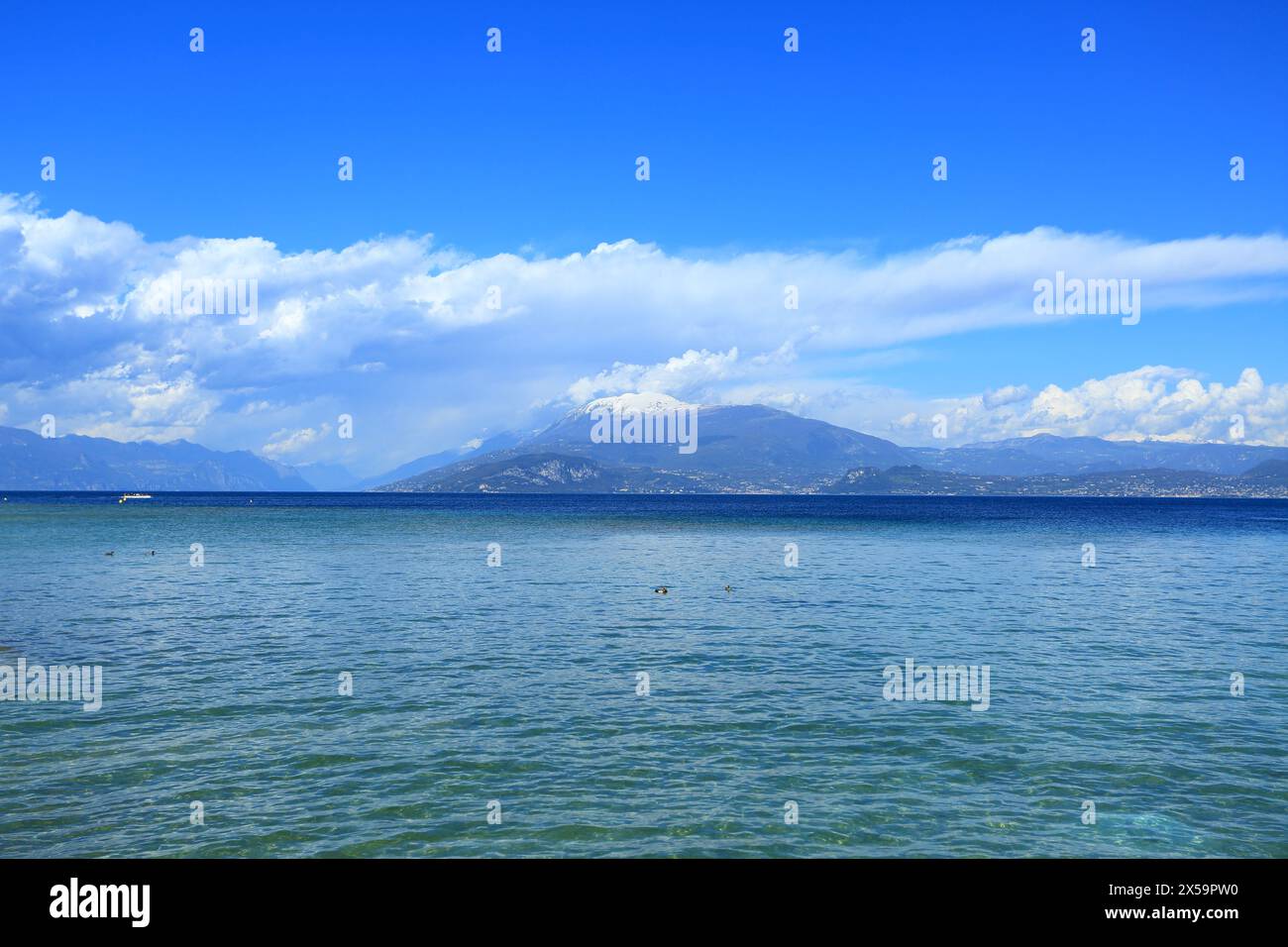 Lago di Gardasee, Blick auf den See und die schneebedeckten Alpen im Hintergrund, Italien Stockfoto
