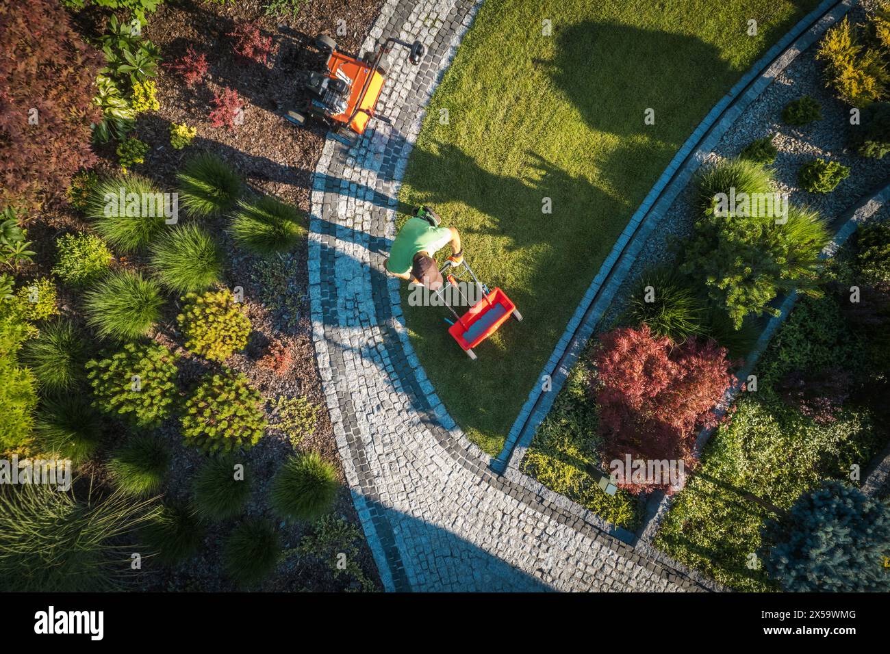 Kaukasischer Gärtner in seinen 40ern düngte Wohngarten im Hinterhof Stockfoto