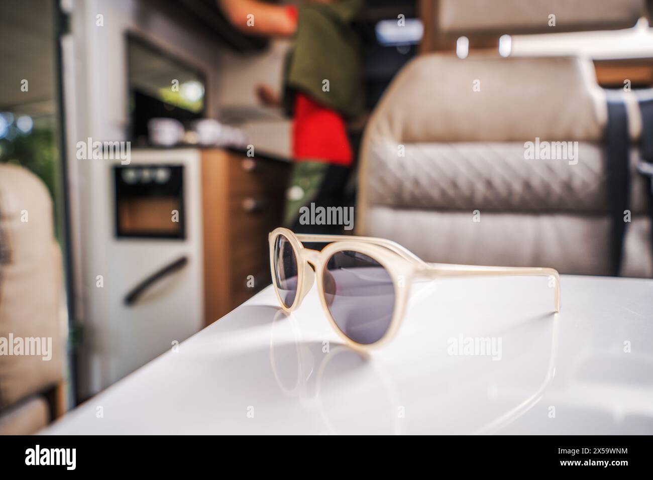 Sonnenbrille auf einem Tisch im modernen Wohnmobil. Urlaub auf der Straße Thema. Freizeitfahrzeuge. Stockfoto