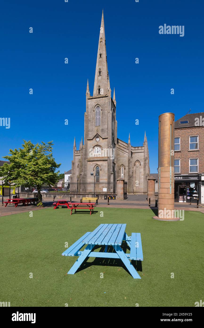 Republik Irland, County Monaghan, Stadt Monaghan, Church Square, St. Patrick's Church of Ireland mit dem Monaghan Memorial, einer Sandstein- und Metallsäule, die vor dem Gericht errichtet wurde, um an die sieben Menschen zu erinnern, die von Loyalisten beim Bombenanschlag in Monaghan am 17. Mai 1974 getötet wurden. Stockfoto