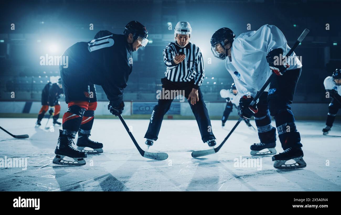 Eishockey Rink Arena Spielstart: Zwei Spieler stehen brutal gegenüber, halten sich bereit, Schiedsrichter wird den Puck fallen lassen, Athleten bereit zu kämpfen. Intensives Spiel Wide of Energy Competition, Geschwindigkeit. Stockfoto