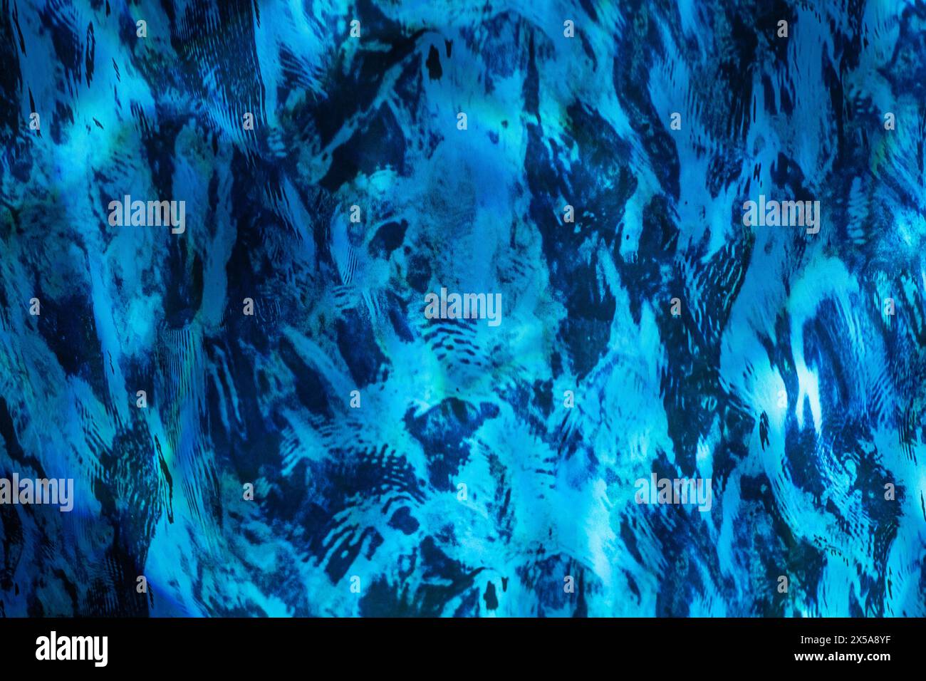 Ein komplizierter abstrakter Hintergrund mit Mustern in Blau und Schwarz, die Aquarellpinselstrichen auf einer strukturierten Oberfläche ähneln. Stockfoto