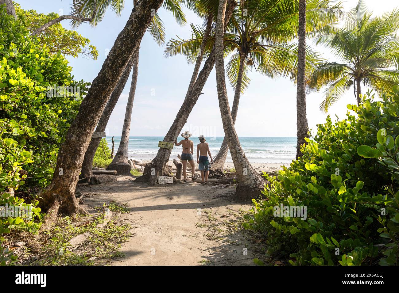 Mutter und Sohn auf einem Familienausflug, Touristen erkunden den Hermosa Strand auf der Nicoya Halbinsel in Costa rica, stehen am Eingang zum Strand, Stockfoto