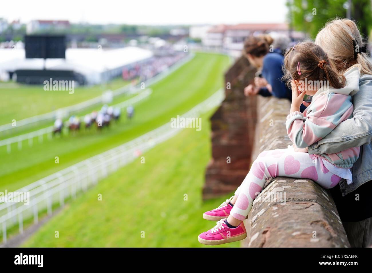 Während des Boodles May Festival Trials Day auf der Chester Racecourse beobachten die Menschen Läufer und Fahrer im CNG Switch Handicap von den Chester City Walls aus. Bilddatum: Mittwoch, 8. Mai 2024. Stockfoto
