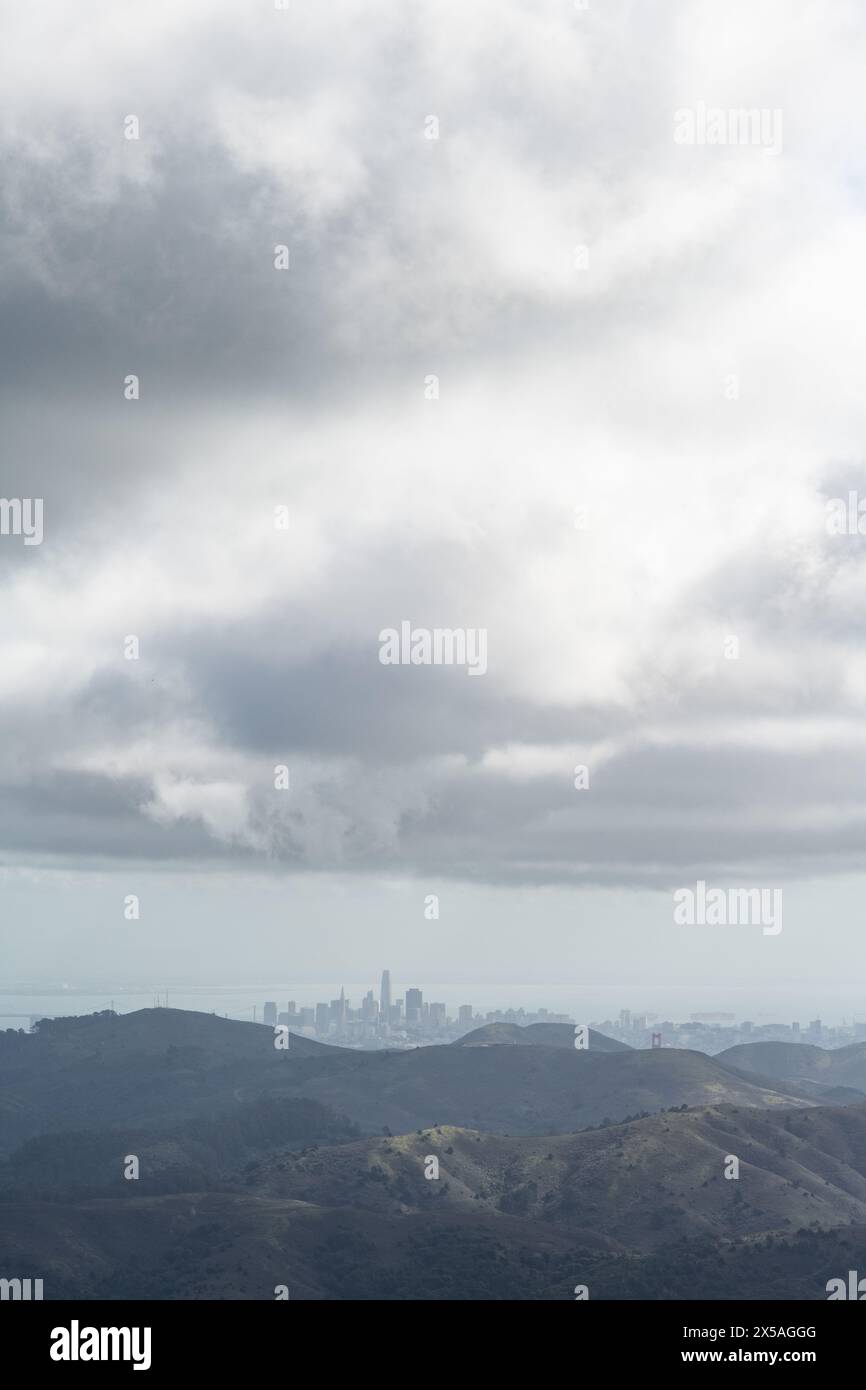 Fernsicht auf die Skyline von San Francisco, durch Nebel und Dunst von einem grünen, im Frühling gelegenen Berg in den Marin Headlands im Norden von Cali Stockfoto