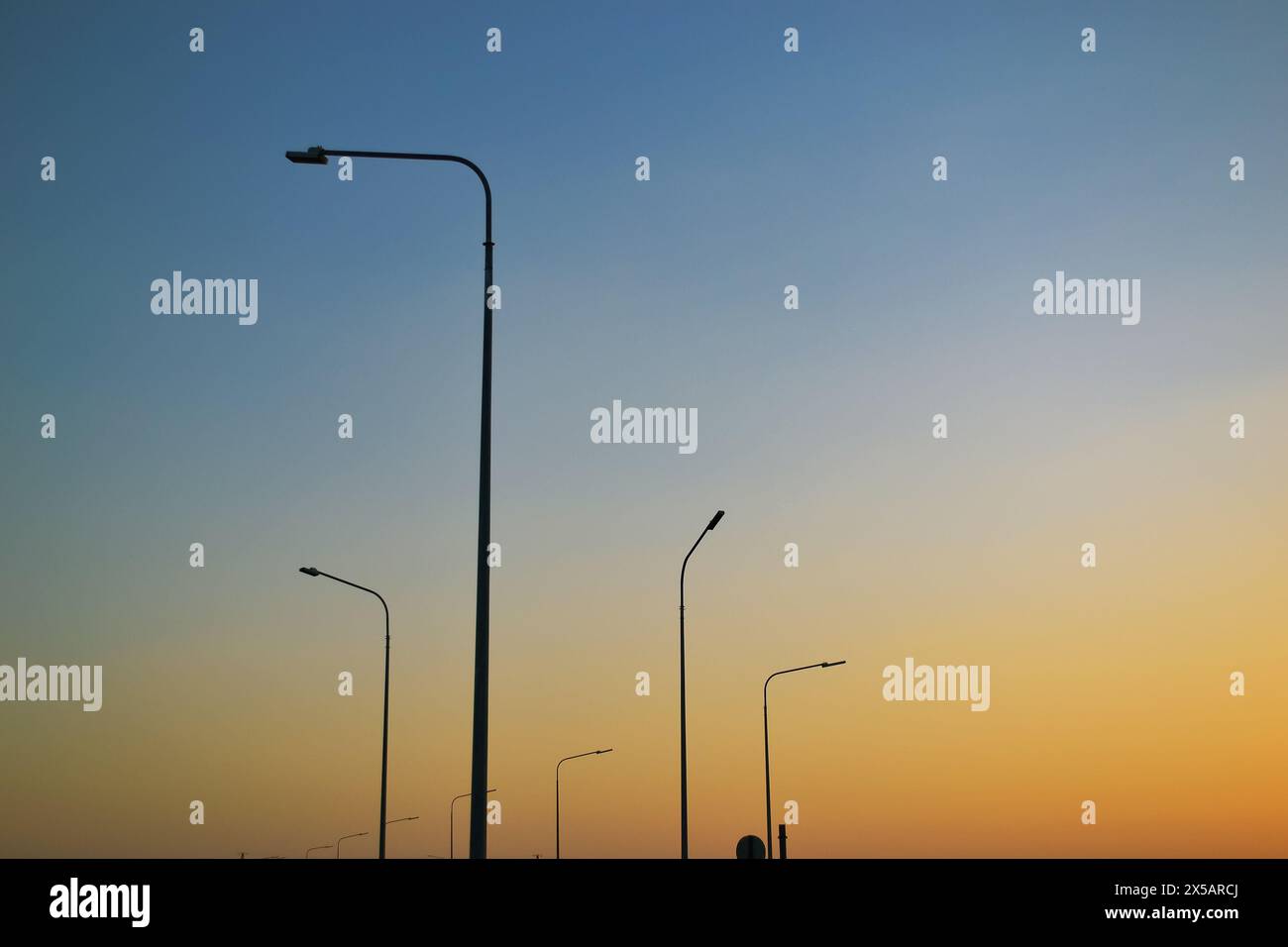 Hohe Laternenpfosten vor dem Hintergrund eines abendlichen klaren Himmels Stockfoto