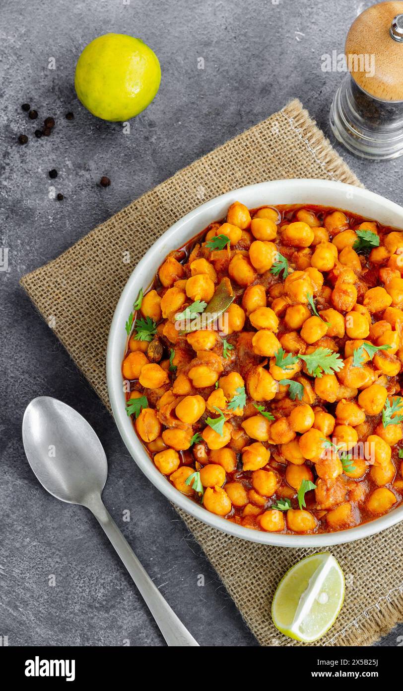 Indisches Kichererbsencurry mit Zitrone in einer Schüssel garniert mit Koriander Stockfoto