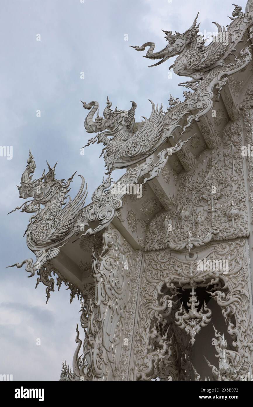 Blick auf die komplizierte und raffinierte Dachlinie, Ecke und den oberen Teil eines Abschnitts des Weißen Tempels in Thailand Stockfoto