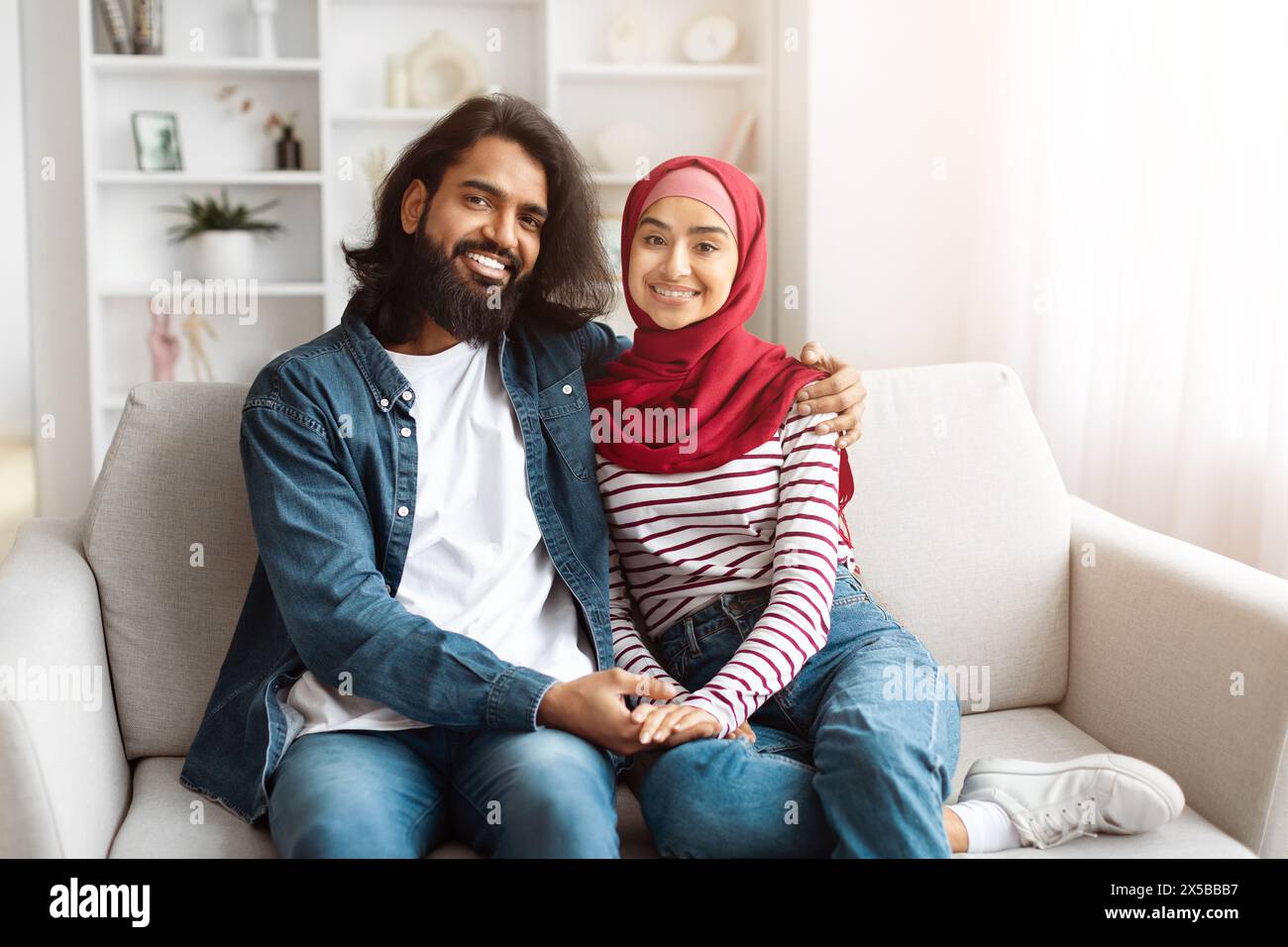Glücklicher Mann und Frau, die auf einer Couch sitzen Stockfoto
