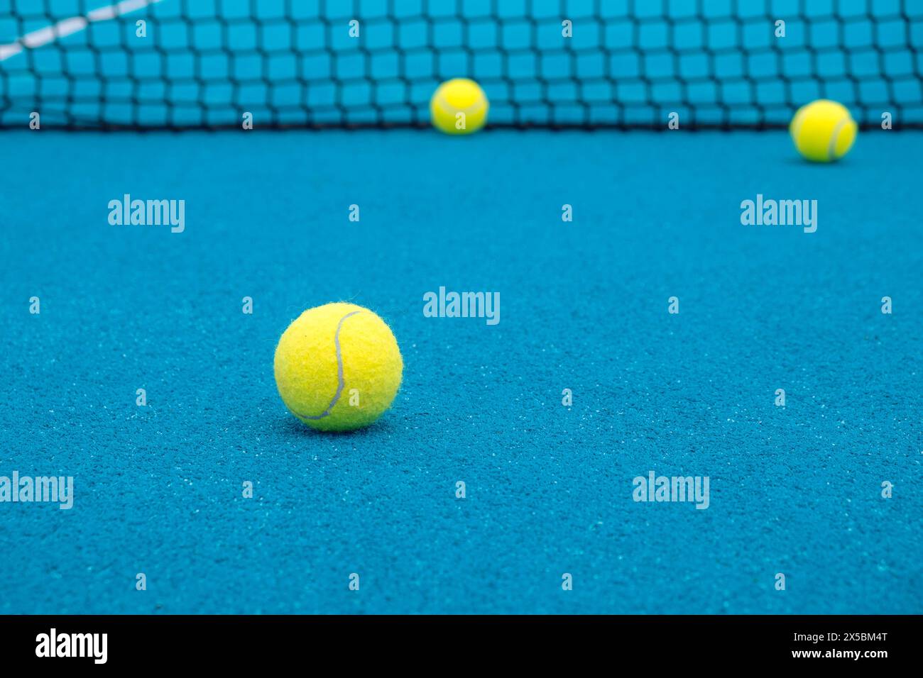 Selektiver Fokus. Paddeltennisbälle auf einem blauen Paddeltennisplatz. Stockfoto