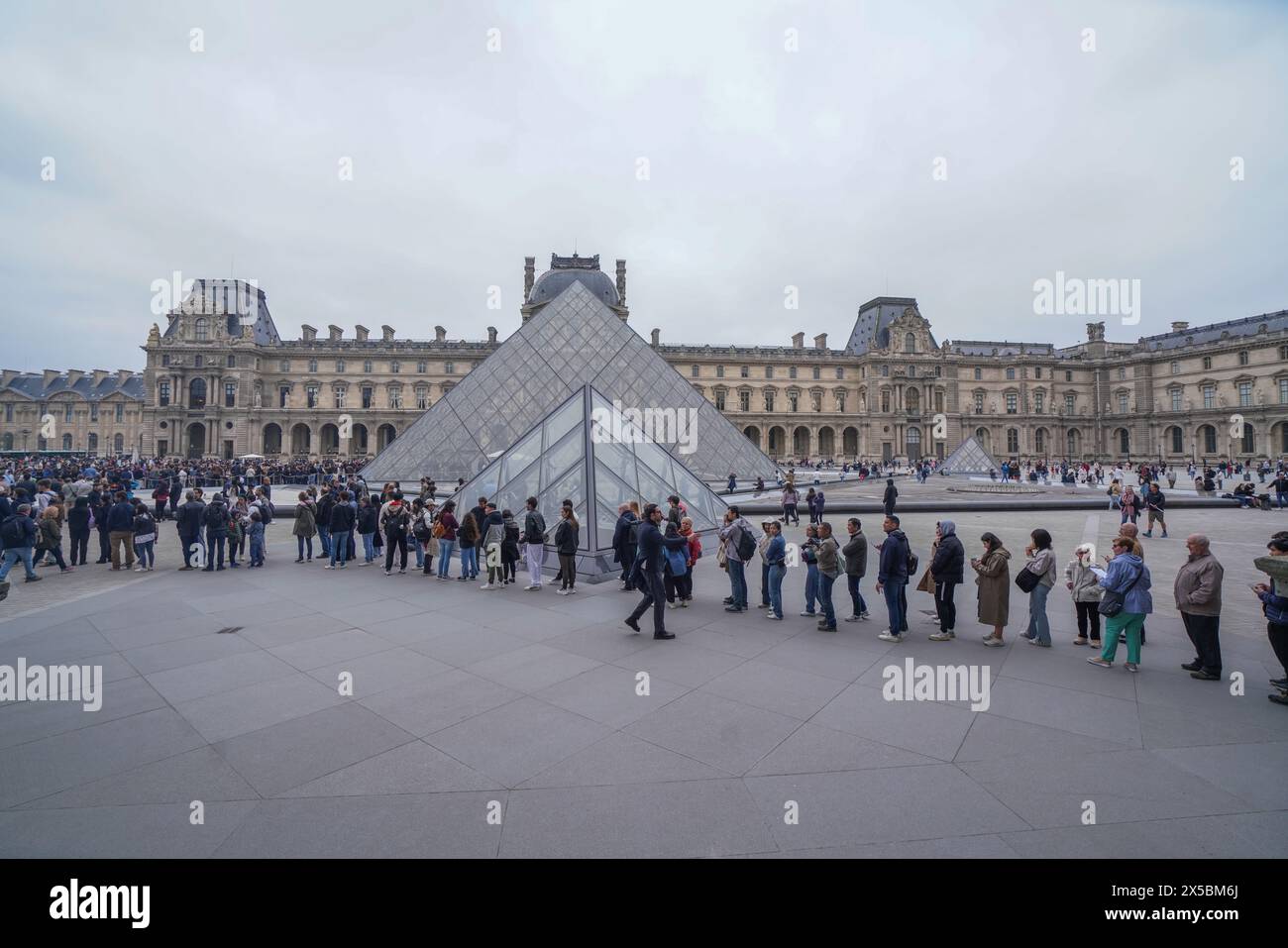 Besucher stehen im Louvre in Paris an Stockfoto