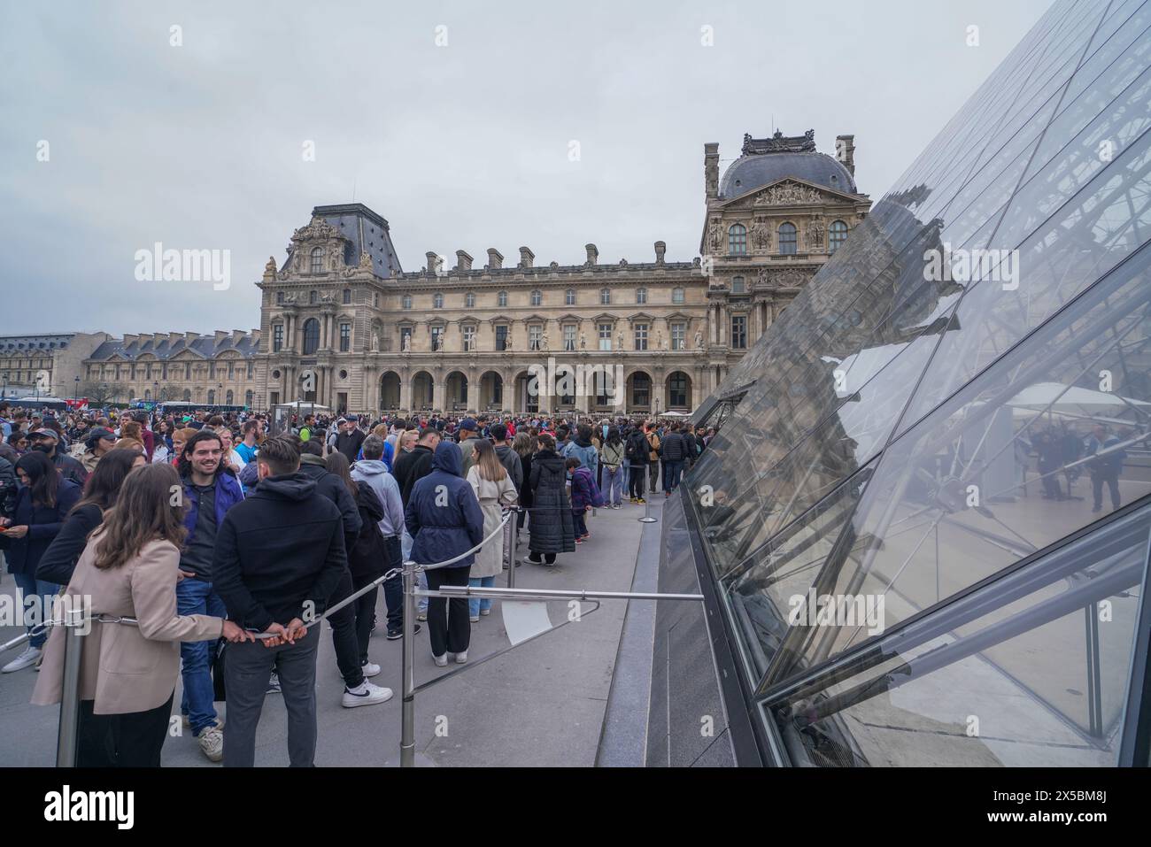 Besucher stehen im Louvre in Paris an Stockfoto