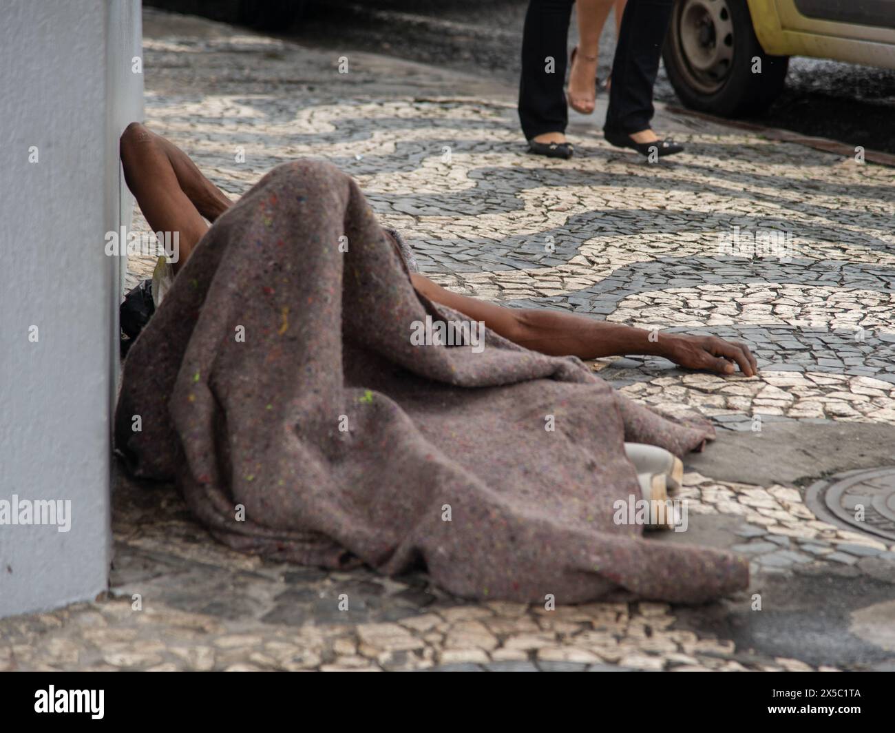 Salvador, Bahia, Brasilien - 12. Mai 2019: Obdachloser schläft tagsüber auf einer Straße im historischen Zentrum der Stadt Salvador, Bahia. Stockfoto