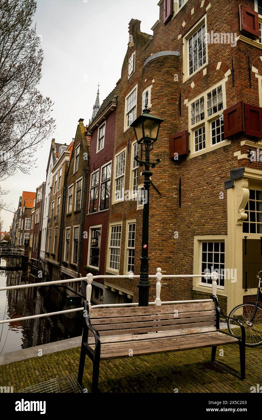 Fußgängerbrücke über einen Kanal und Backsteinturm oder Mauerturm in Delft, Holland. Stockfoto