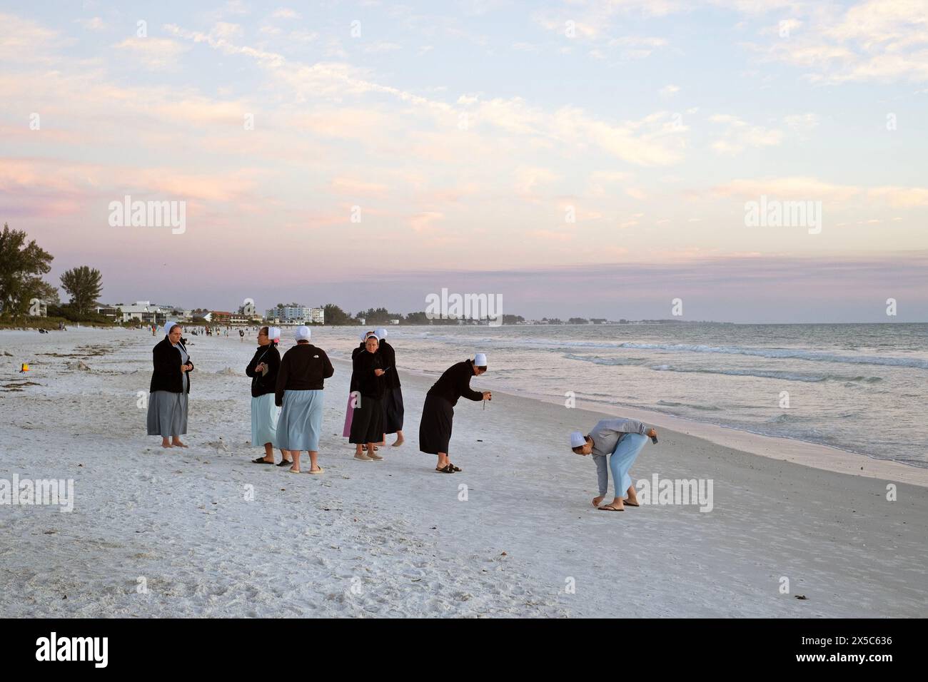 Eine Gruppe mennonitischer Frauen verbringt Zeit am Strand auf Anna Maria Island, Florida, USA. Stockfoto