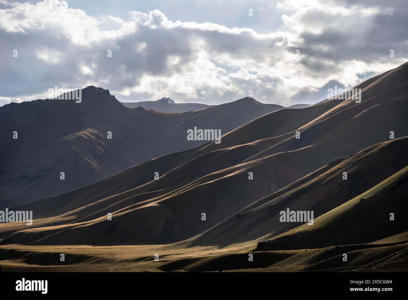 Bergsilhouette und Hügel im Sonnenlicht, dramatische Berglandschaft, Tian Shan, Sky Mountains, Sary Jaz Valley, Kirgisistan Stockfoto