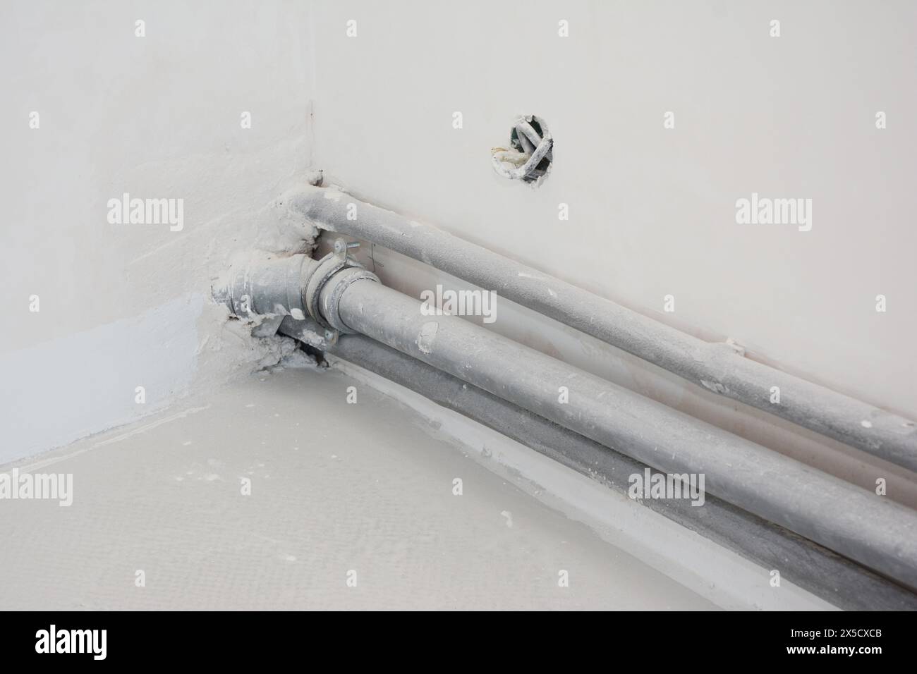 Schließen Sie nach dem Verputzen pvc-Rohre in der im Bau befindlichen Ecke der Küchenwand. Stockfoto