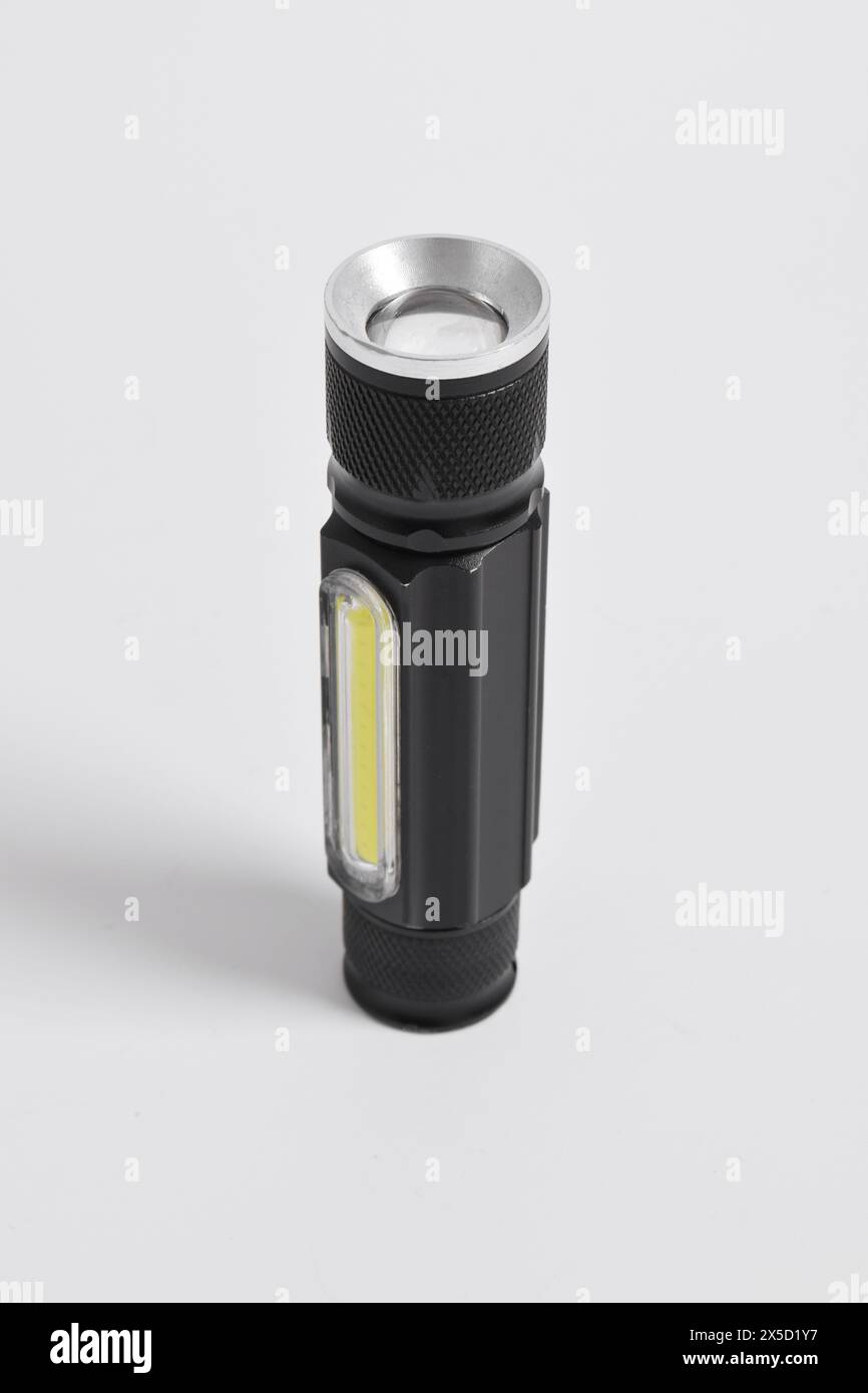 Moderne Metall-LED-Taschenlampe in schwarzer Farbe isoliert auf weißem Hintergrund. Tragbare Taschenlampe, LED-Campinglampe Stockfoto