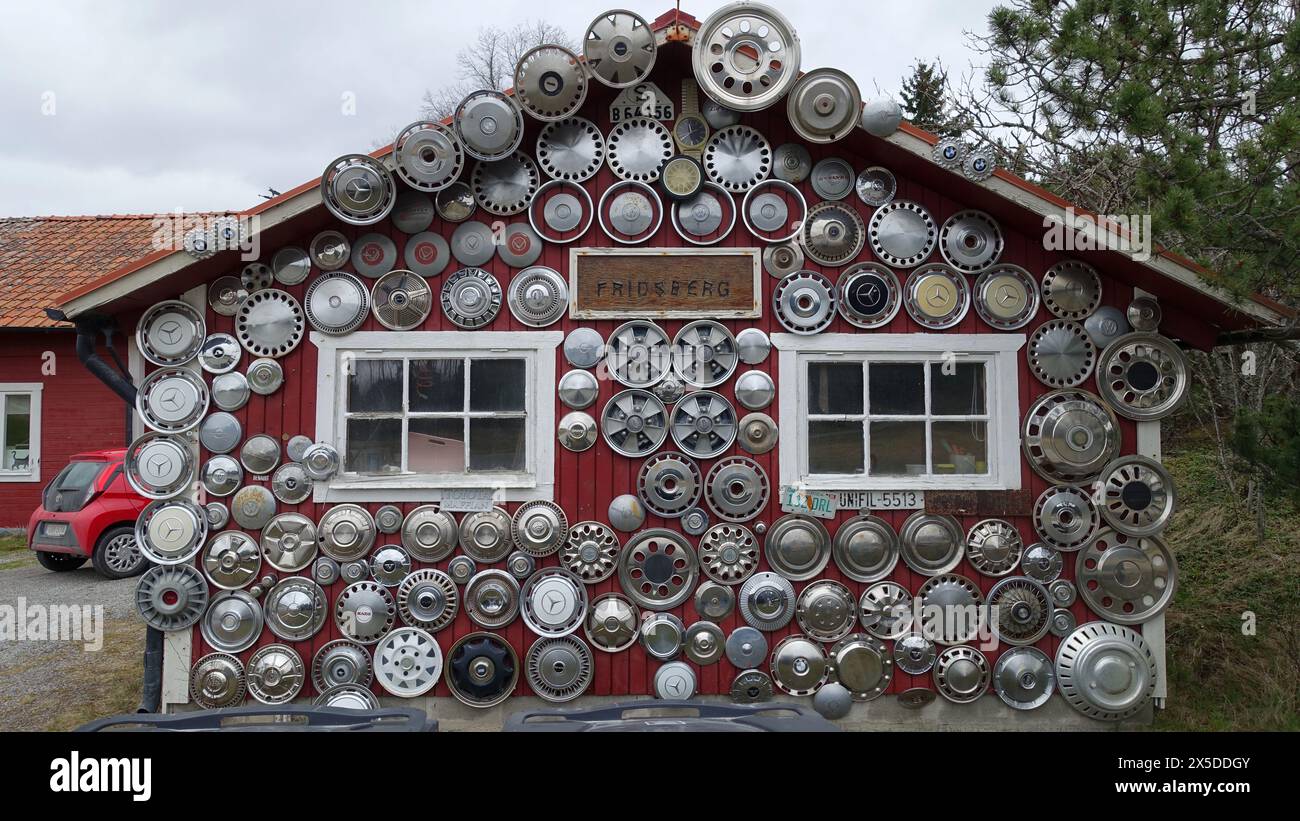 Schweden, 21. April 2024. Die Fassade eines Hauses mit antiken Felgen. Blick von der Straße an einem bewölkten Tag. Stockfoto