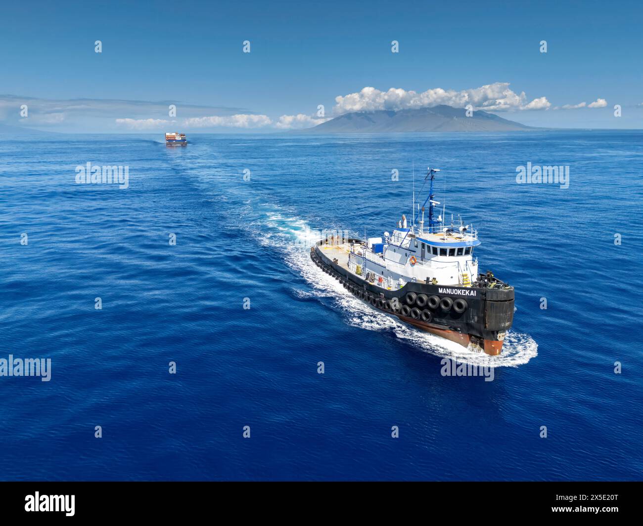 Ein Blick aus der Vogelperspektive auf das Schlepper Manuokekai, das einen Lastkahn mit Containern durch den Alalakeiki-Kanal in Süd-Maui, Hawaii, USA zieht. Stockfoto