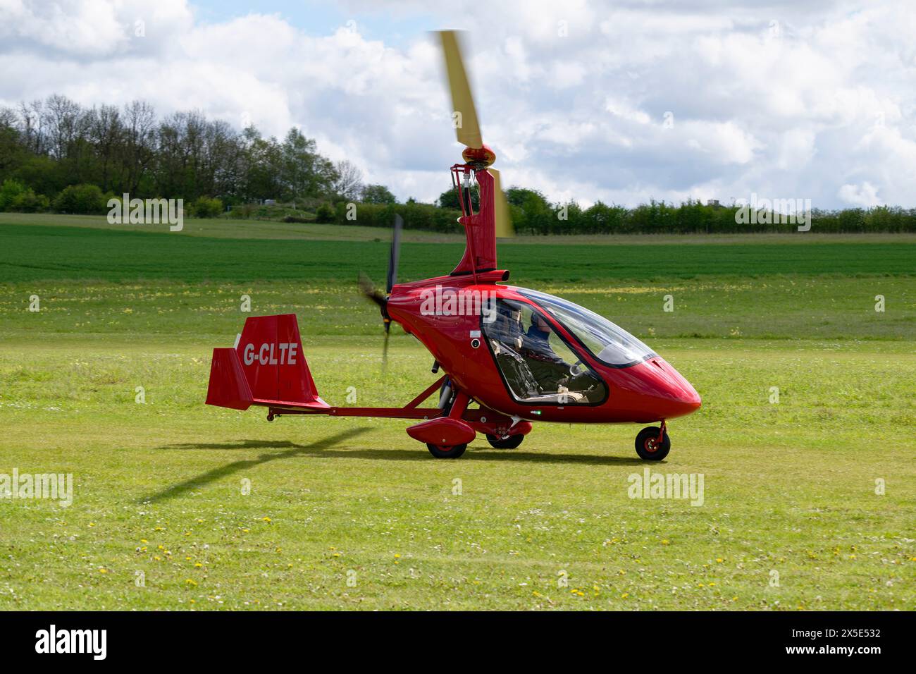 Der Smart Red Magni M24 Gyrocopter G-CLTE trifft auf dem Flugplatz Popham nahe Basingstoke Hampshire ein, um an der jährlichen Microlight Flyin- und Fachmesse teilzunehmen Stockfoto
