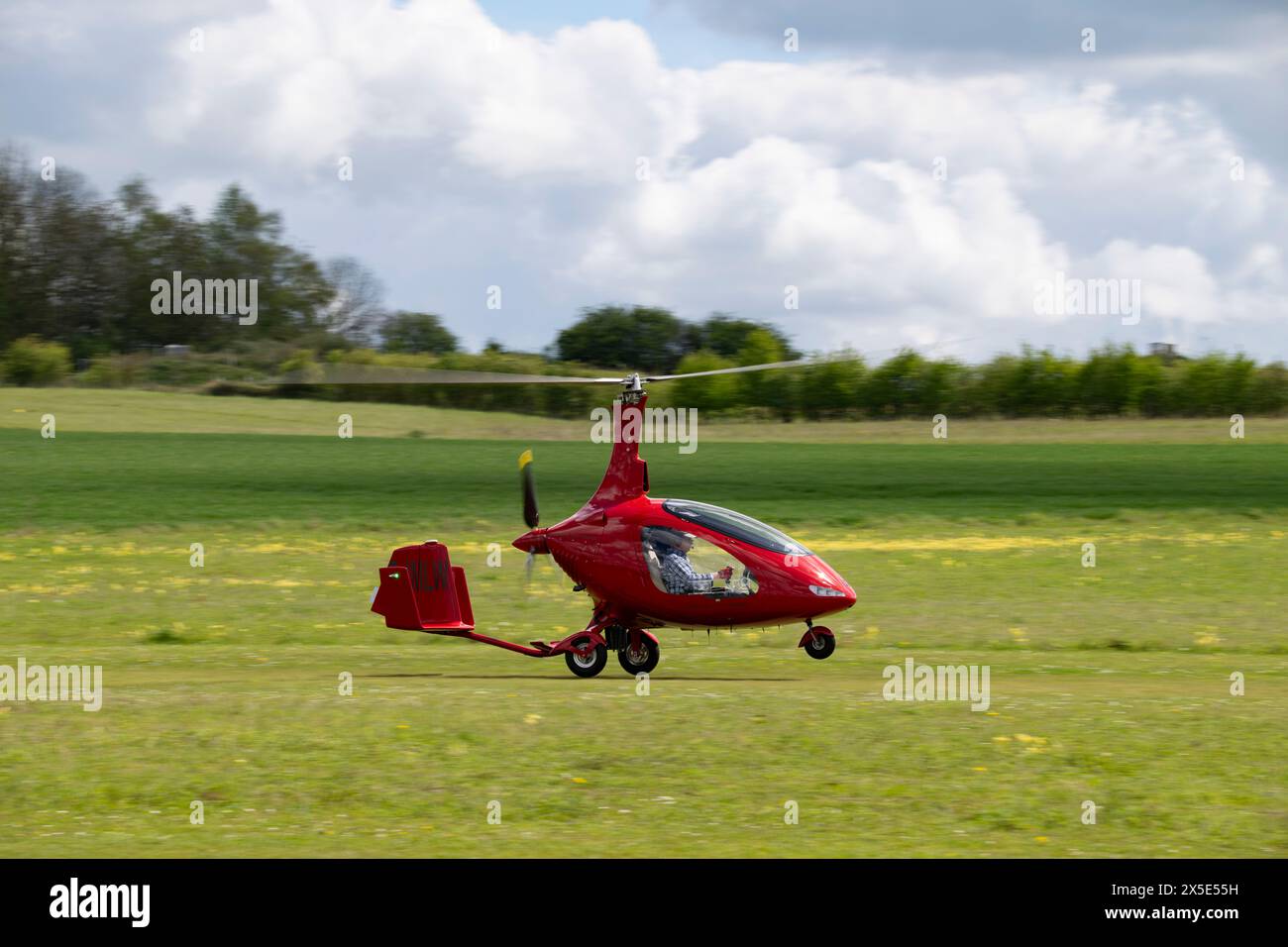 Smart Red Rotorsport Cavalon Gyroplane G-IMLW trifft am Flughafen Popham in der Nähe von Basingstoke Hampshire ein, um an dem jährlichen Mikrolicht-Flug teilzunehmen Stockfoto