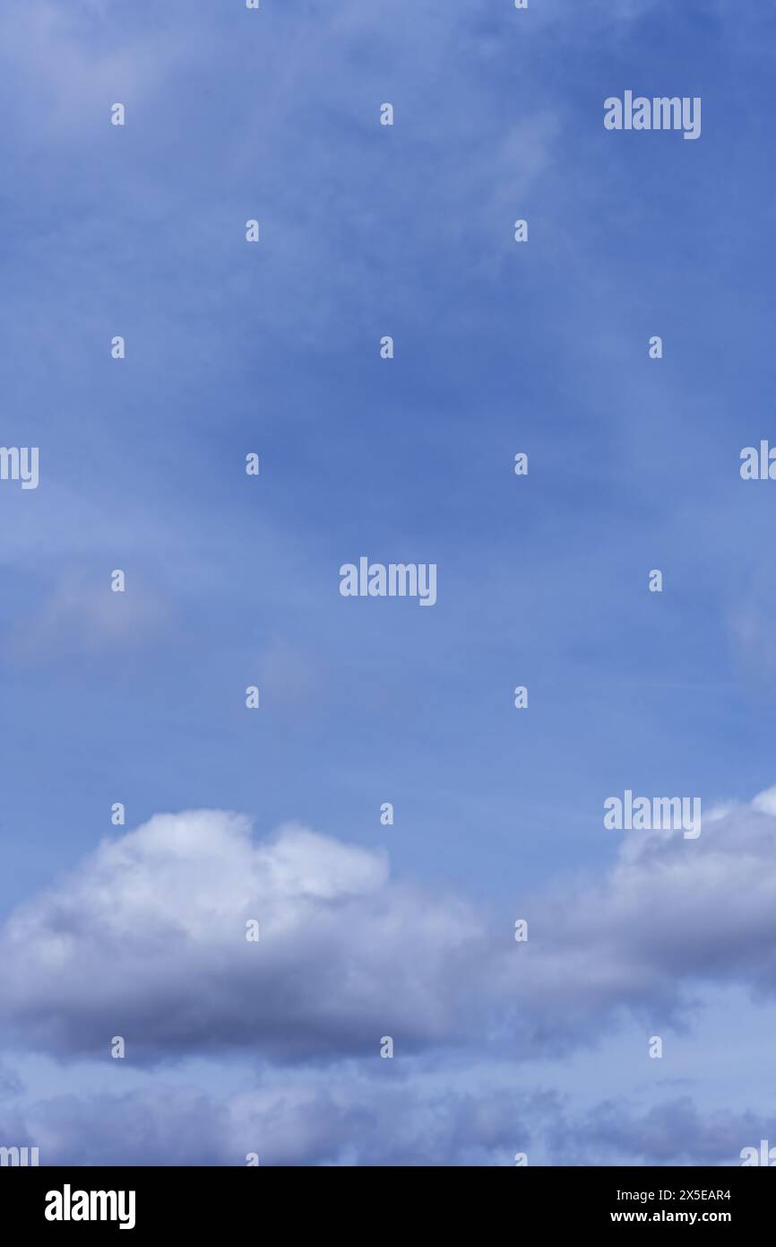 Eine Landschaft mit blauem Himmel mit weißen Quellwolken, die mit Wasser beladen sind. Vektor flauschiger Texturhintergrund Stockfoto