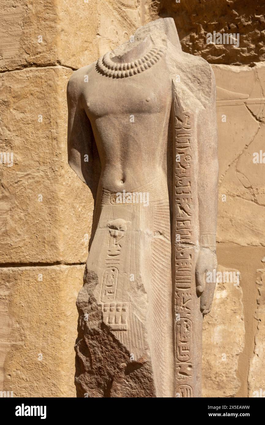 Eine kopflose Statue, geschnitzt mit einer perlenbesetzten doppelten Halskette und Hieroglyphen. In der Großen Hypostilhalle des Karnak-Tempels, Ägypten. Stockfoto