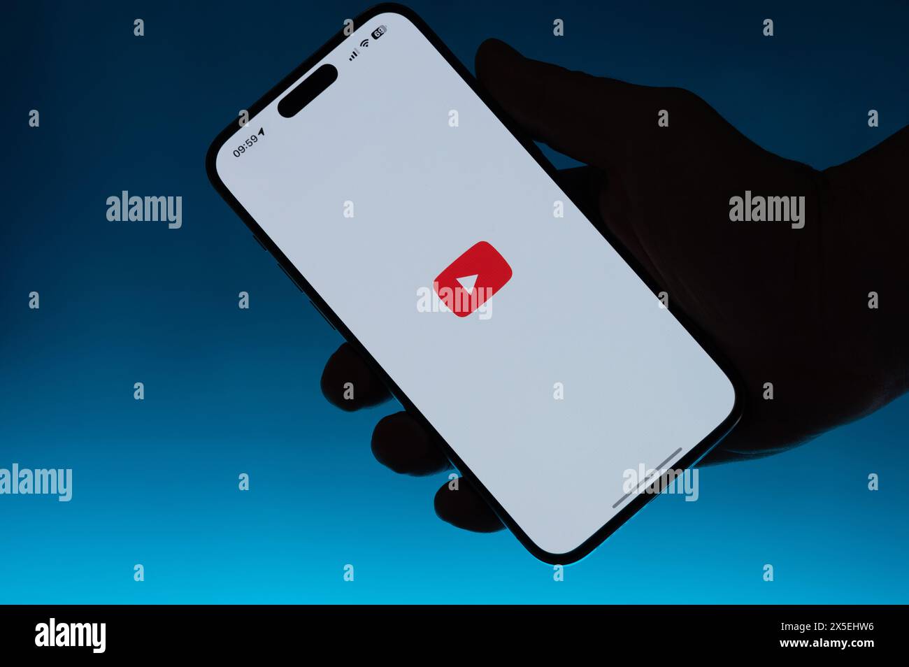New York, USA – 6. Mai 2024: Öffnen Sie die youtube-App auf dem Smartphone in Hand isolierter blauer Farbverlauf Stockfoto
