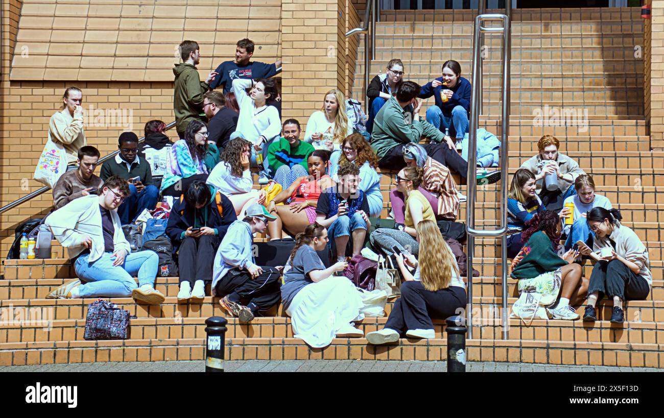 Glasgow, Schottland, Großbritannien. 9. Mai 2024: UK Weather: Studenten auf den Eingangspunkten des Royal conservatoire of Scotland treffen sich mittags auf der Treppe, um die Sonne zu genießen. Sonniges Sommerwetter für Einheimische und Touristen im Stadtzentrum. Credit Gerard Ferry/Alamy Live News Stockfoto