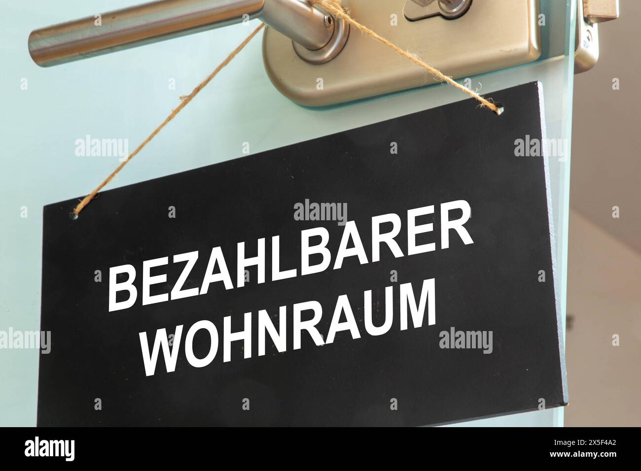 Schild mit der Aufschrift BEZAHLBARER WOHNRAUM an einer Tür Symbolbild *** Schild mit der Aufschrift BEZAHLBARER WOHNRAUM auf einer Tür Symbolbild Copyright: XUdoxHerrmannx Stockfoto