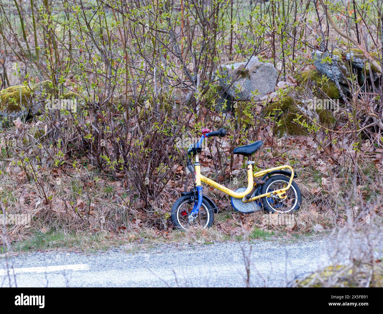 Göteborg, Schweden - 20. April 2024: Kinderfahrrad links am Straßenrand zur Vorsicht für Autofahrer. Keine sichtbaren Personen. Stockfoto