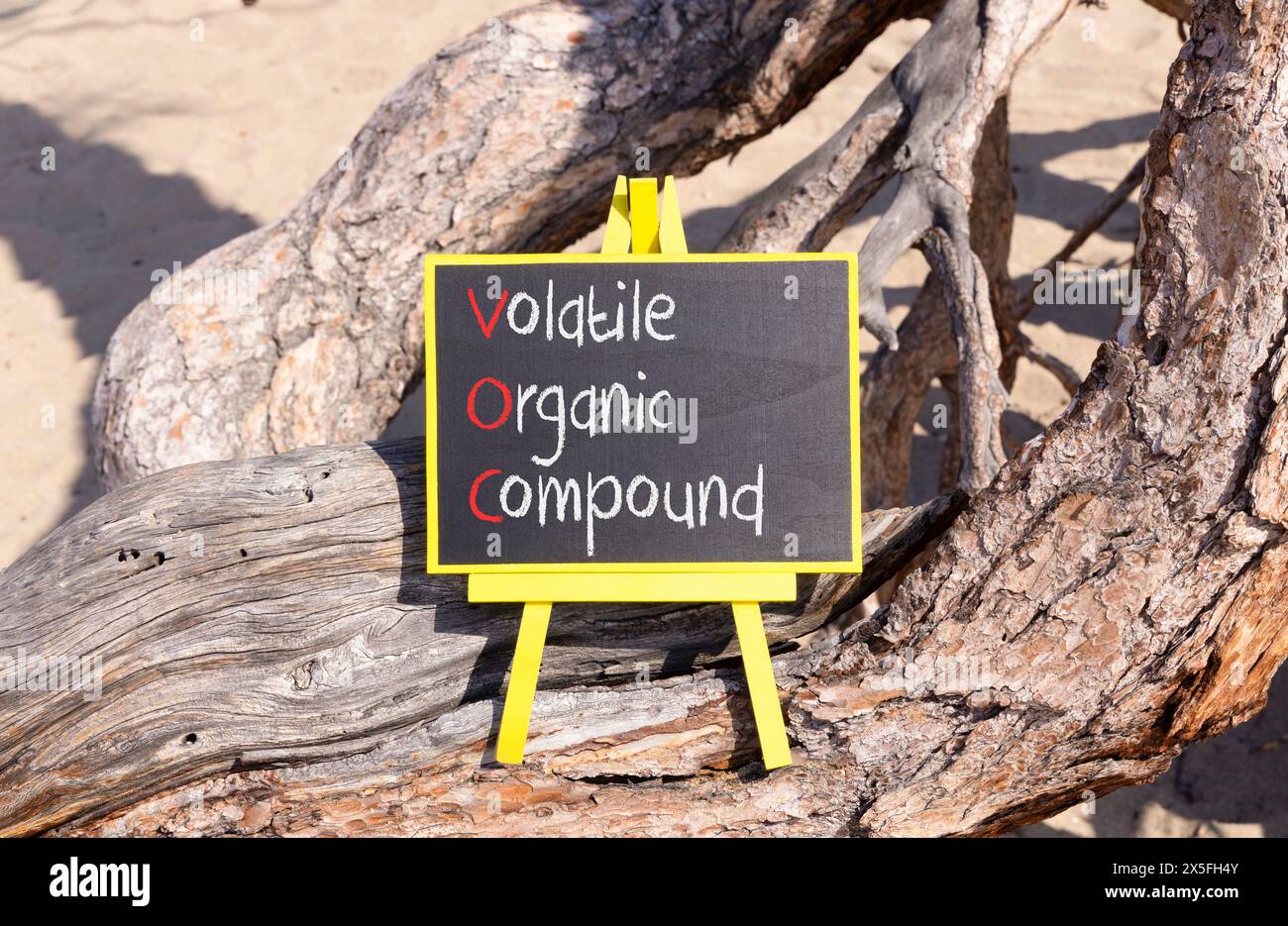 VOC-Symbol für flüchtige organische Verbindungen. Konzeptworte VOC flüchtige organische Verbindung auf schöner gelber Tafel. Wunderschöner Baumhintergrund. Unternehmen Stockfoto