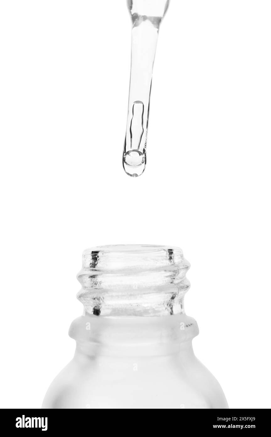 Tropfen von Flüssigkeit aus der Pipette in Flasche isoliert auf weiß, Nahaufnahme Stockfoto
