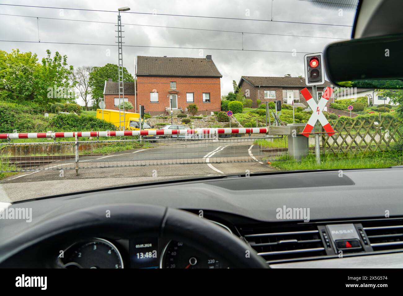 Auto wartet auf einem Bahnübergang, geschlossene Schranken, rote Warnleuchte, Ampel und Andreaskreuz, bei Geilenkirchen NRW, Deutschland, Stockfoto