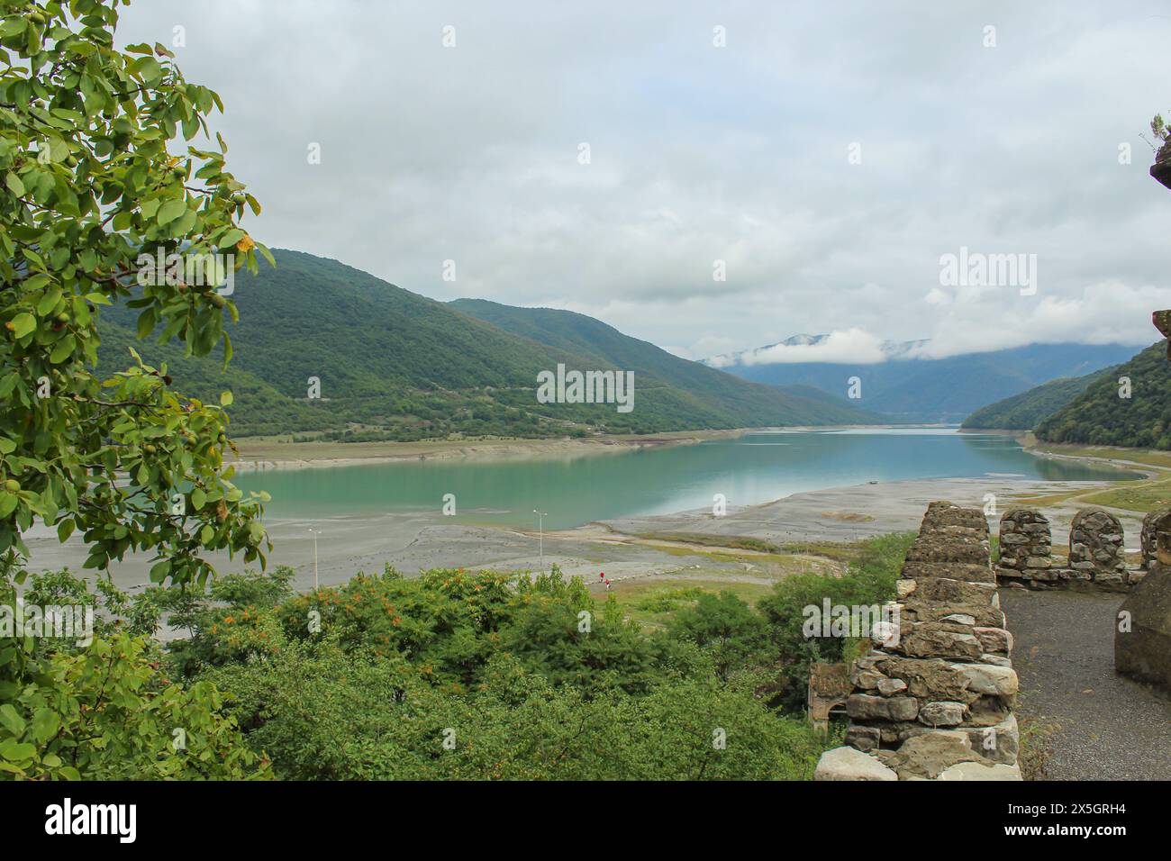 Malerischer Blick auf die Ananuri Festung Komplex mit türkisfarbenem Wasser des Zhinvali Reservoir umgeben von Bergen auf dem georgischen Militär Stockfoto